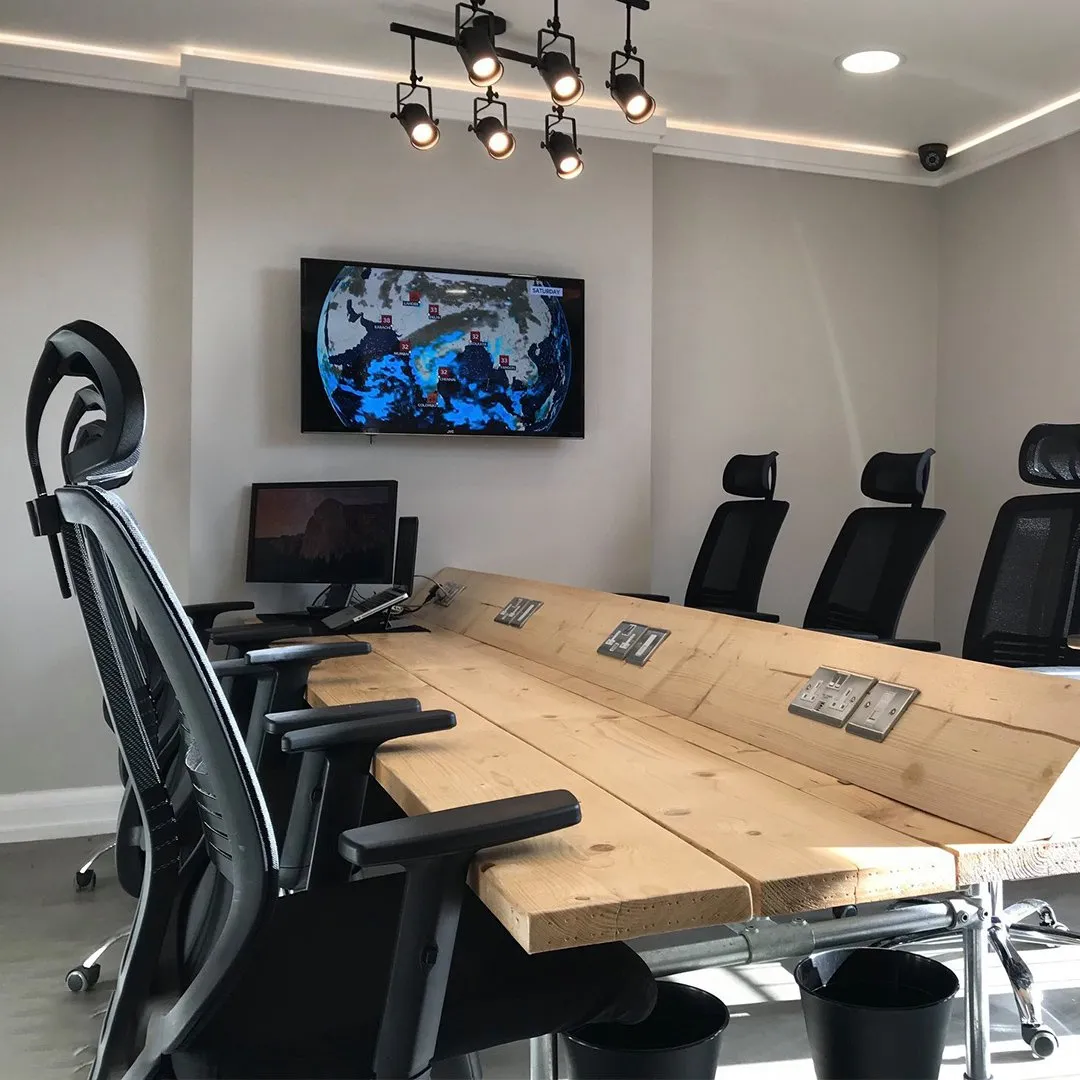 The boardroom at ShiftWorks Market Street, Hoylake, with a scaffold-board table and screen